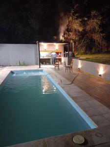 una piscina en un patio trasero por la noche en MAIPU Apart en Maipú