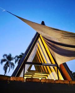 un techo de una casa con una ventana y una palmera en Chalé Aconchegante - TEMOS O CHALÉ BRANCO DISPONÍVEL NESTE FINAL DE SEMANA, en Camboriú