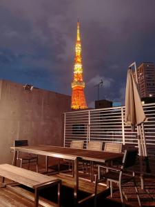uma mesa com cadeiras e um guarda-sol e uma torre em Azabu Modern House em Tóquio