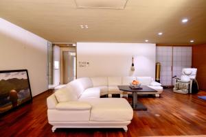sala de estar con sofá blanco y mesa en Azabu Modern House, en Tokio