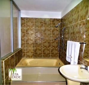 a bathroom with a bath tub and a sink at Apartamento Vacacional Vista Verde in Tarapoto