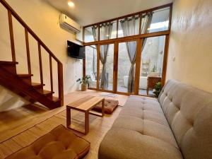uma sala de estar com um sofá e uma mesa em นา-ใบบุญ Nabaiboon em Chiang Khan