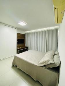 a bedroom with a large bed with a window at Estúdio no Polo Médico do Recife, Ap.804 in Recife