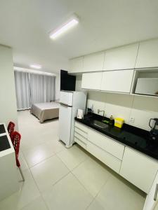 a kitchen with a refrigerator and a bed in a room at Estúdio no Polo Médico do Recife, Ap.804 in Recife