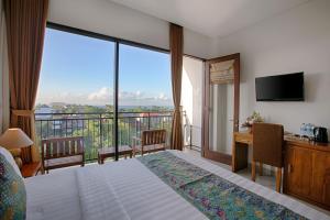 Una habitación de hotel con una cama y una ventana grande. en My Villa and Resort Canggu, en Canggu