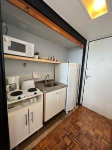 una pequeña cocina con fregadero y nevera. en Studio Top en Microcentro en Buenos Aires