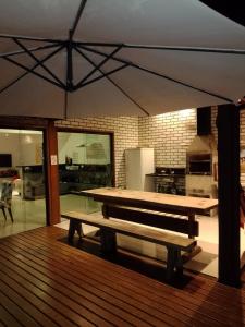 una terraza de madera con una mesa en la cocina en Casa Lua, en Ilhabela
