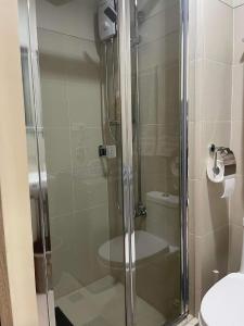 La salle de bains est pourvue d'une douche en verre et de toilettes. dans l'établissement Condo Hotel with Balcony, à Manille