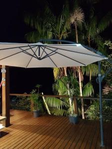 una gran sombrilla blanca en una terraza de madera en Casa Lua, en Ilhabela