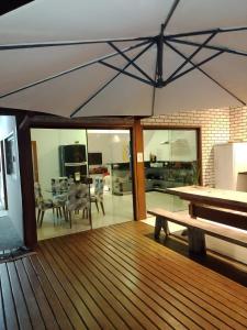 una terraza de madera con un banco y un comedor en Casa Lua, en Ilhabela