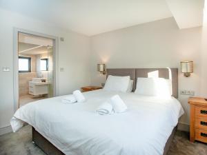 ein Schlafzimmer mit einem großen weißen Bett mit zwei Kissen in der Unterkunft The Cowrie in Turnchapel