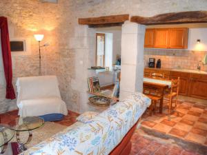 a kitchen and a living room with a couch and a table at Gîte Chemillé-sur-Indrois, 3 pièces, 4 personnes - FR-1-381-444 in Chemillé-sur-Indrois