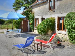 a patio with chairs and a table and an umbrella at Gîte Chemillé-sur-Indrois, 3 pièces, 4 personnes - FR-1-381-444 in Chemillé-sur-Indrois