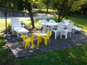 un grupo de sillas y mesas en un patio de ladrillo en Gîte Bransat, 3 pièces, 4 personnes - FR-1-489-38 en Bransat