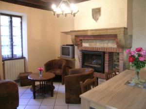 a living room with a fireplace and a table and chairs at Maison Indépendante avec Grand Jardin et Cheminée, Proche Saint Pourçain - Confort et Tranquillité - FR-1-489-38 in Bransat