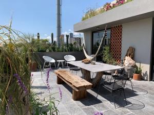 a patio with a wooden table and chairs at Design Penthouse private panoramic terrace in La Concepción