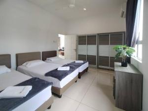 Bandar Penawar的住宿－Desaru Spacious 30pax Bungalow with Netflix near Beach，一间卧室配有两张床和一张植物书桌