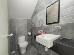 a bathroom with a sink and a toilet and a mirror at Desaru Spacious 36pax Bungalow with Netflix near Beach in Bandar Penawar +19 photos