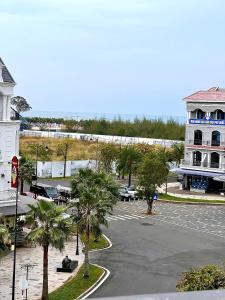 ein leerer Parkplatz mit einem Gebäude und Palmen in der Unterkunft Lex Homestay Hotel in Phu Quoc