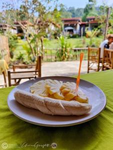 a sandwich on a plate on a table with a fork in it at Phurin Thara Resort in Ko Lanta