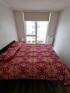 a bed in a room with a large window at 408/ Precioso apartamento 1D+1B /(3 camas)/ JUMBO+CENTRO 5 MIN in Puerto Montt