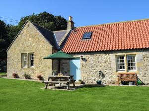 a stone house with a picnic table in the yard at The Old Frame House in Rock