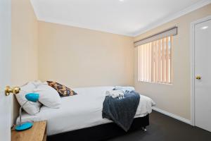 Schlafzimmer mit einem Bett und einem Fenster in der Unterkunft Bea-Vic Home. Your home away from home. in Kalgoorlie