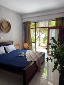 a bedroom with a bed with a blue comforter at Coconut Palm beach restaurant and rooms in Dickwella
