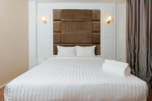 a bedroom with a large white bed with white sheets at Calinton Hotel in Udon Thani