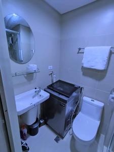 ein Badezimmer mit einem Waschbecken, einem WC und einem Spiegel in der Unterkunft 1 Bedroom with balcony in Manila