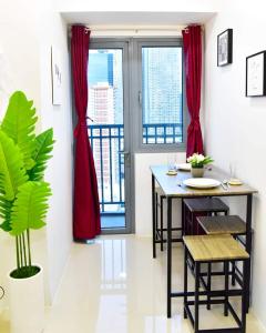 ein Esszimmer mit einem Tisch und roten Vorhängen in der Unterkunft 1 Bedroom with balcony in Manila