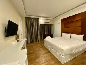 ウドーンターニーにあるCalinton Hotelのベッドとテレビが備わるホテルルームです。