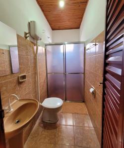 a bathroom with a shower and a toilet and a sink at Residencial da Praça in Bonito