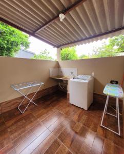 Cette chambre comprend un bureau, une table et une chaise. dans l'établissement Residencial da Praça, à Bonito