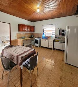a kitchen with a table and a refrigerator at Residencial da Praça in Bonito