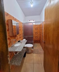 uma casa de banho com um WC, um lavatório e um chuveiro em Residencial da Praça em Bonito