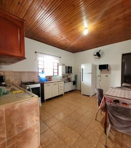 a kitchen with a white refrigerator and a table at Residencial da Praça in Bonito