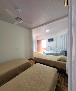 um quarto de hotel com duas camas e uma televisão em Residencial da Praça em Bonito