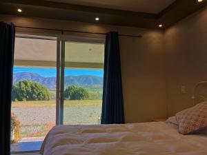 a bedroom with a bed and a window with a view at Mi Casa en el Valle de Guadalupe in Valle de Guadalupe