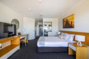 a hotel room with a bed and a desk at Aligned Corporate Residences Townsville in Townsville
