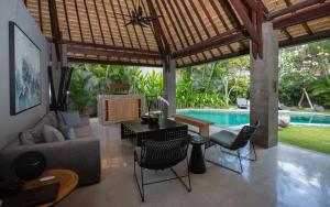 ein Wohnzimmer mit einem Sofa, einem Tisch und einem Pool in der Unterkunft The Amala Boutique Retreat in Seminyak