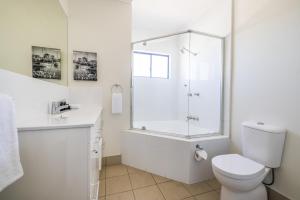 a white bathroom with a shower and a toilet at Aligned Corporate Residences Townsville in Townsville