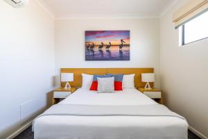 a bedroom with a large bed and two lamps at Aligned Corporate Residences Townsville in Townsville