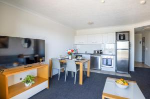 a kitchen with a table and a dining room at Aligned Corporate Residences Townsville in Townsville +9 photos
