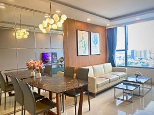 a dining room with a table and a couch at River gate Yourhomes 2br in Ho Chi Minh City