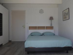 a bedroom with a large bed with white sheets and blue pillows at Maison Bangor, 3 pièces, 4 personnes - FR-1-418-215 in Bangor