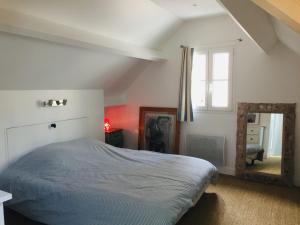 una camera da letto con un letto e uno specchio di "Duplex de charme au cœur de Le Palais, proche commerces et plages, moderne et tout équipé" - FR-1-418-219 a Le Palais