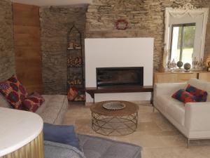a living room with a couch and a fireplace at Maison contemporaine au calme près de la plage, WiFi inclus - FR-1-418-198 in Locmaria