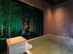 a bath tub in a room with a large window at Bettei Fujiya in Miyajima