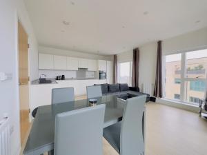 a kitchen and living room with a glass table and chairs at Luxurious Comfy Penthouse - Steps to East Croydon Train Station - Views in Croydon